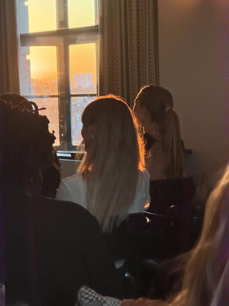 The photo captures an indoor scene at Spuistraat, Centrum, Amsterdam, bathed in the warm glow of the setting sun through a large window